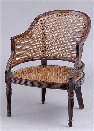 Appraisal: REGENCY CARVED MAHOGANY AND CANE TUB-BACK ARMCHAIR The bowed reeded