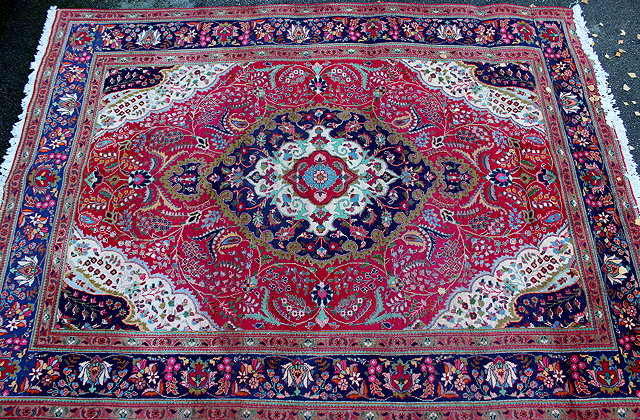 Appraisal: A REDGROUND TABRIZ RUG with central foliate motif and multiple