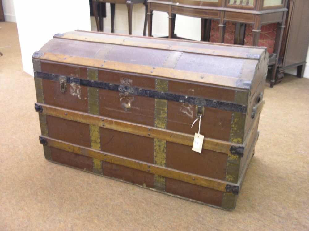 Appraisal: A wood and brass bound domed top trunk