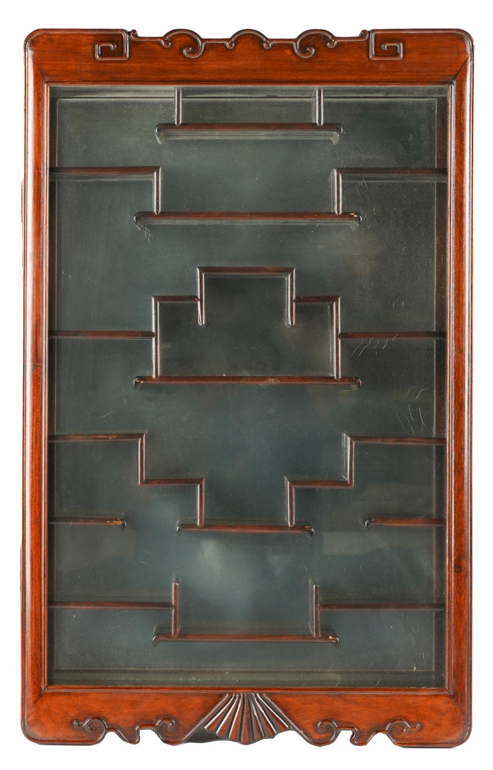 Appraisal: CHINESE-STYLE MAHOGANY WALL DISPLAY CASEhaving a glazed hinged door and