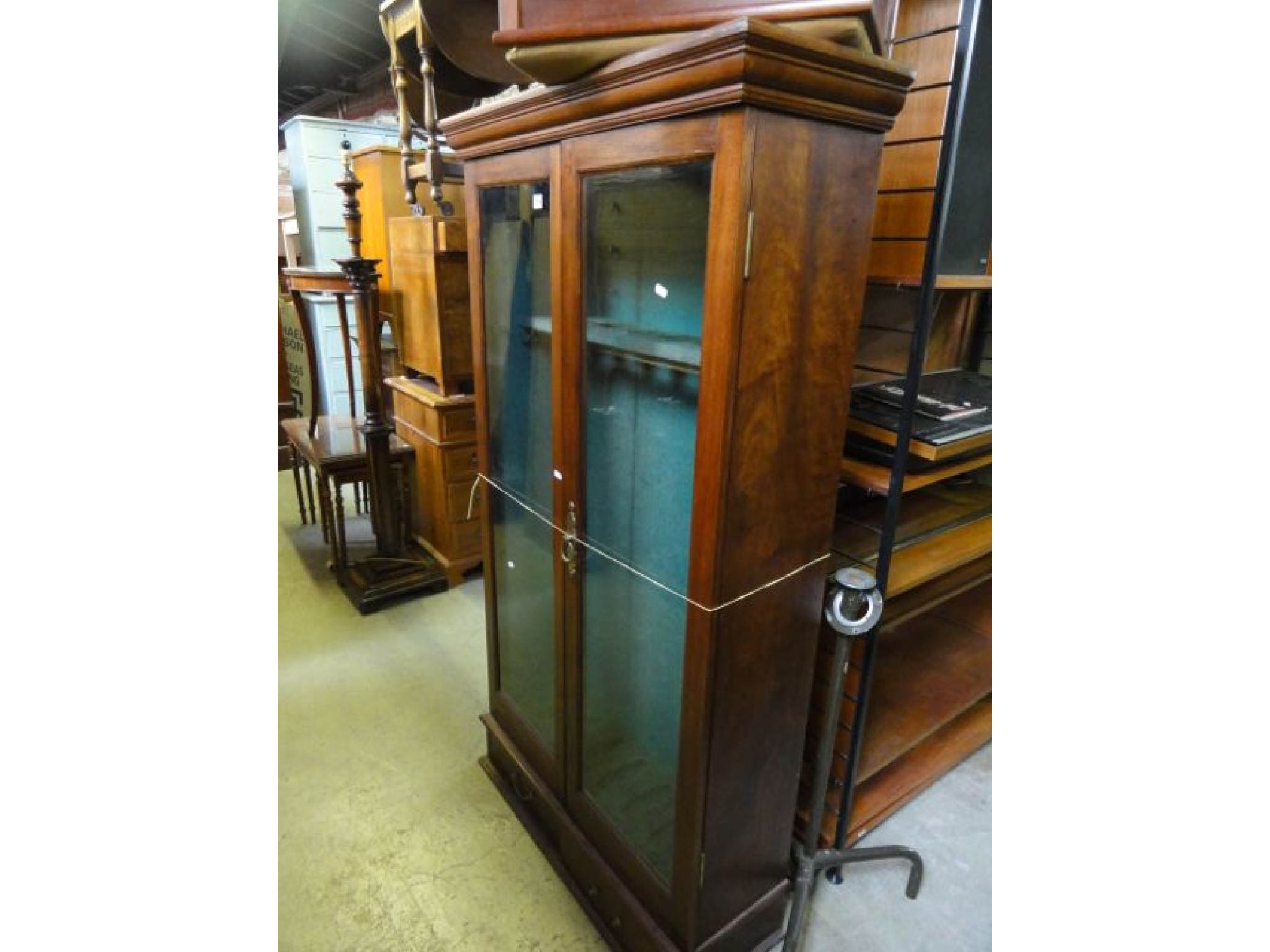 Appraisal: A vintage mahogany gun cabinet enclosed by a pair of