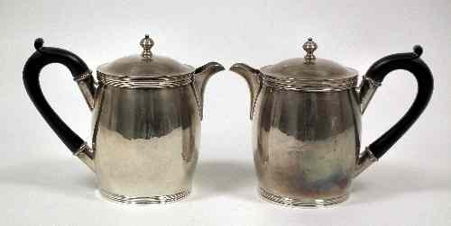 Appraisal: A pair of George V silver bulbous hot water jugs