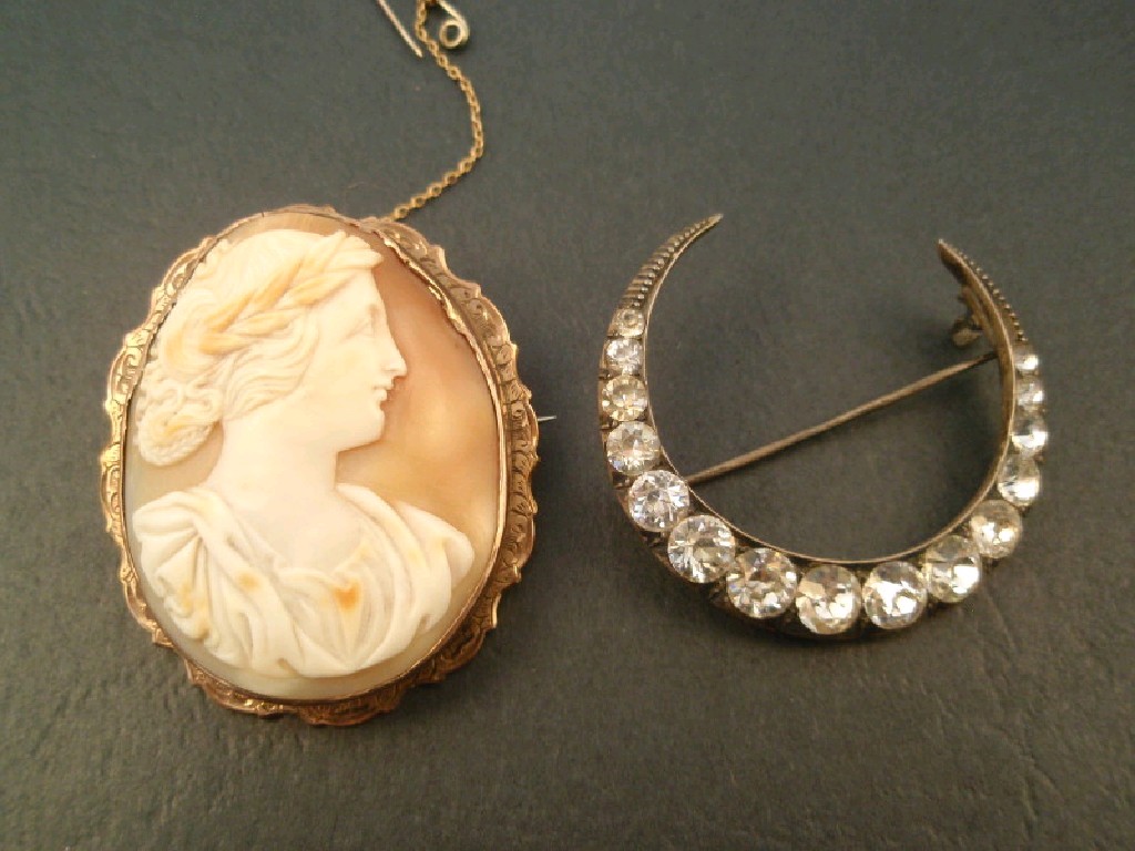 Appraisal: A crescent brooch set with graduated white stones in white