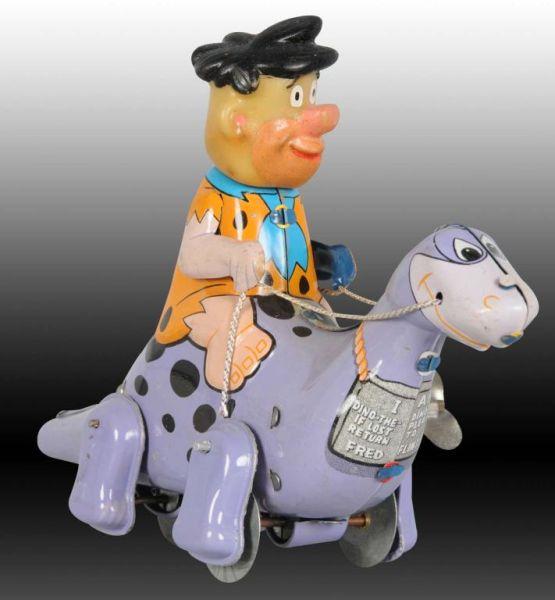 Appraisal: Marx Tin Wind-Up Fred Flintstone Riding Dino Toy Description Toy