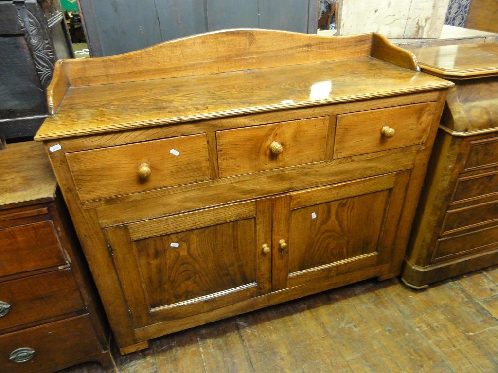 Appraisal: An antique oak country made dresser base side cupboard with