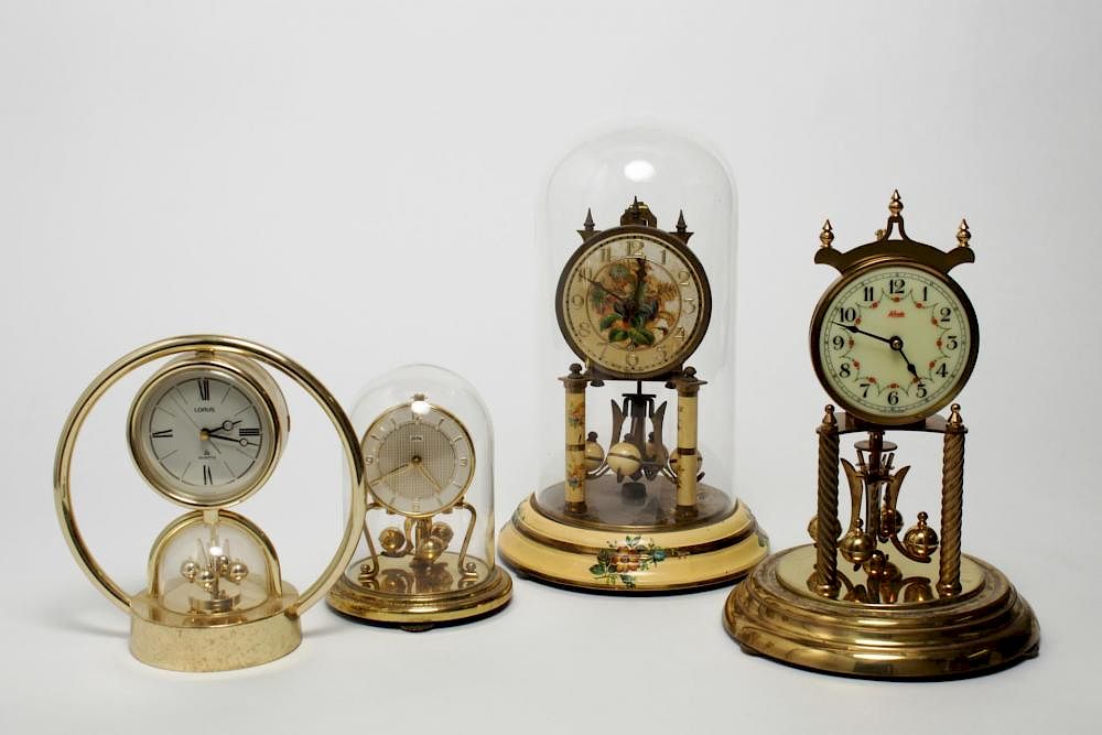 Appraisal: German Japanese Torsion Pendulum Clocks German and Japanese gold-tone metal