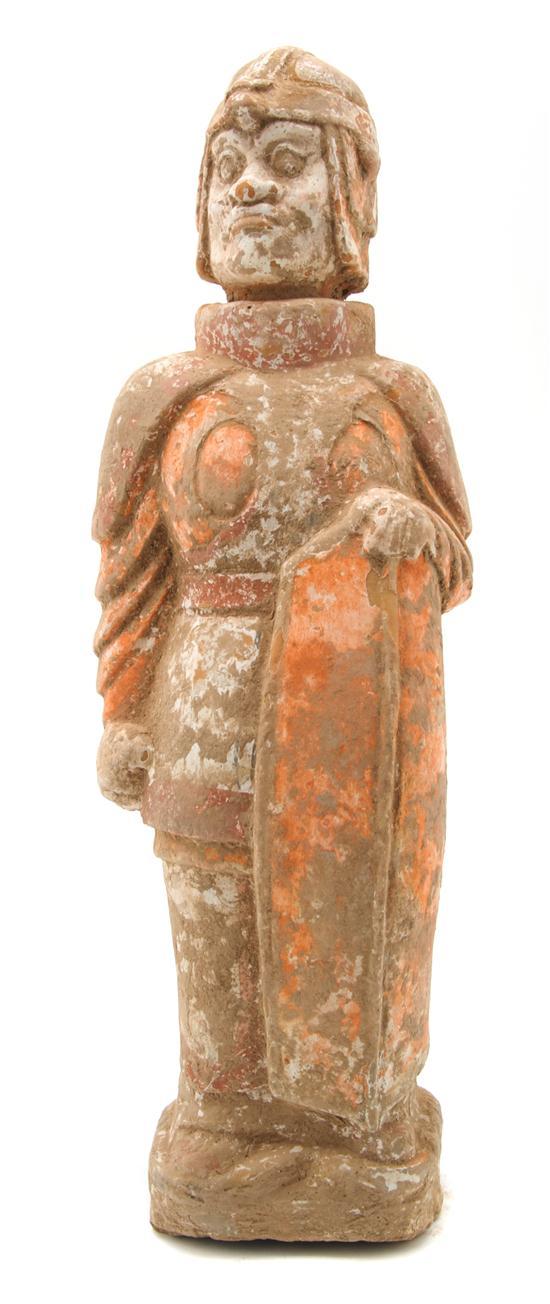 Appraisal: Chinese Pottery Tomb Figure depicting a standing soldier holding a