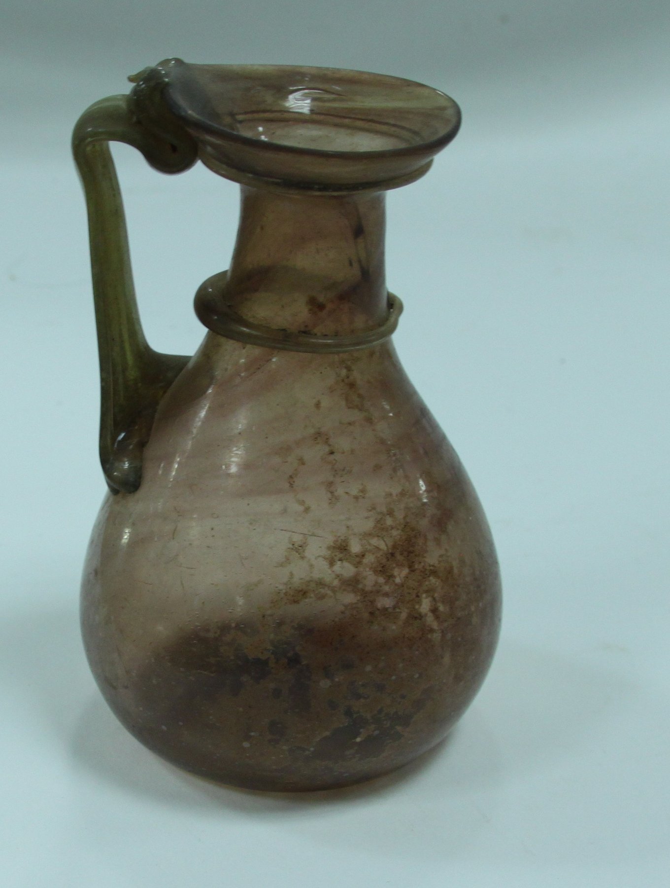 Appraisal: An ancient Roman glass jug with flared rim and ringed