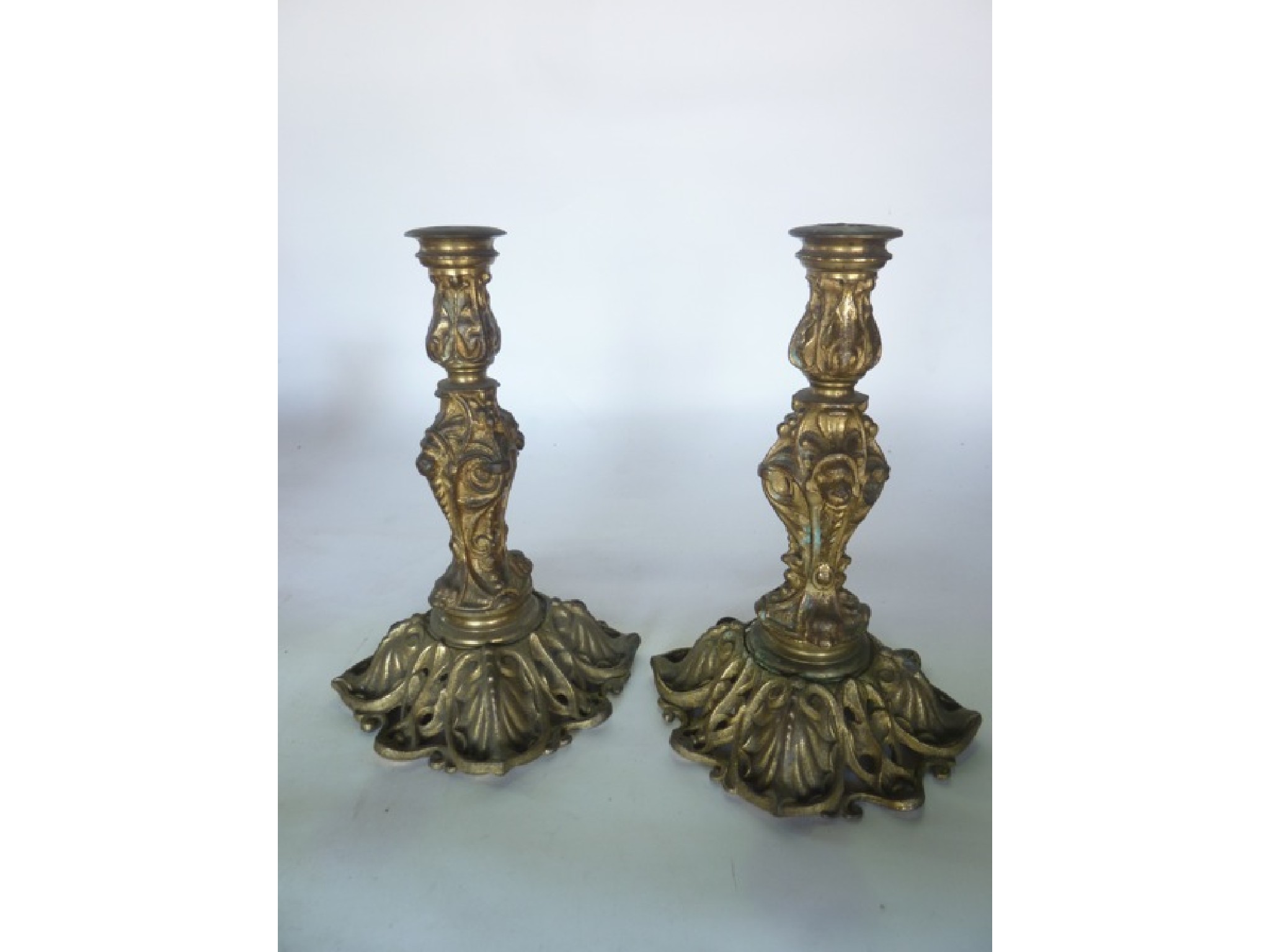 Appraisal: A pair of heavy cast brass candlesticks with lion mask