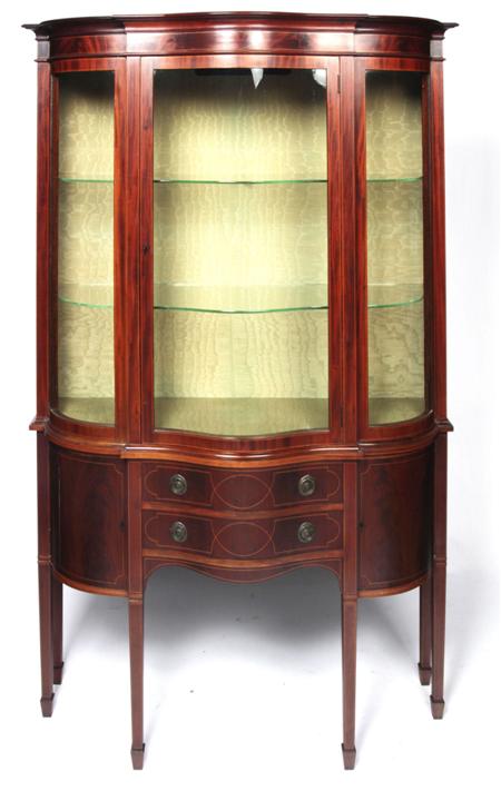 Appraisal: An Edwardian mahogany serpentine display cabinet the projected moulded cornice