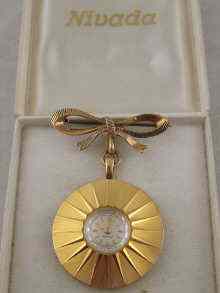 Appraisal: A gold plated lady's lapel watch by Nivada the case