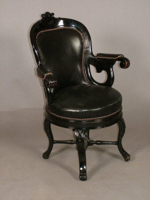 Appraisal: A late Victorian ebonised and black leather swivel armchair with