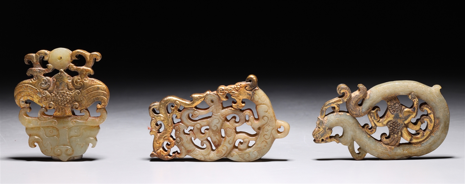 Appraisal: Three Chinese carved and gilt jade toggles of various designs