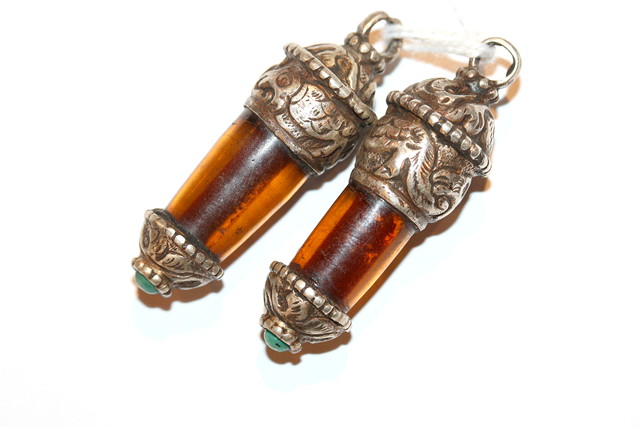 Appraisal: A PAIR OF WHITE METAL AND AMBER PENDANTS set with