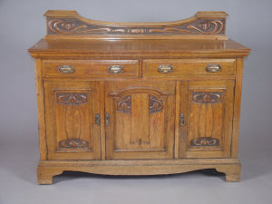 Appraisal: A limed oak side cabinet circa with two carved panelled