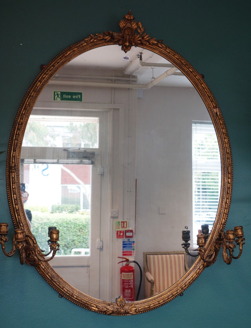 Appraisal: A large Victorian oval gilt framed wall mirror mounted with