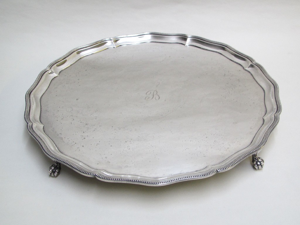 Appraisal: A silver salver with shaped gadroon rim and on claw