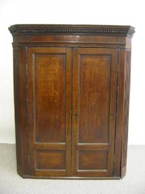 Appraisal: A GEORGE III OAK CORNER CUPBOARD c the moulded dentil