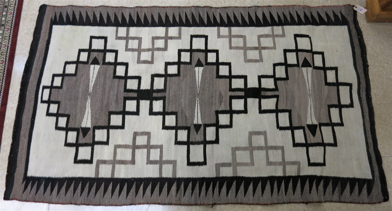 Appraisal: HAND WOVEN NAVAJO RUG featuring three geometric medallions and four