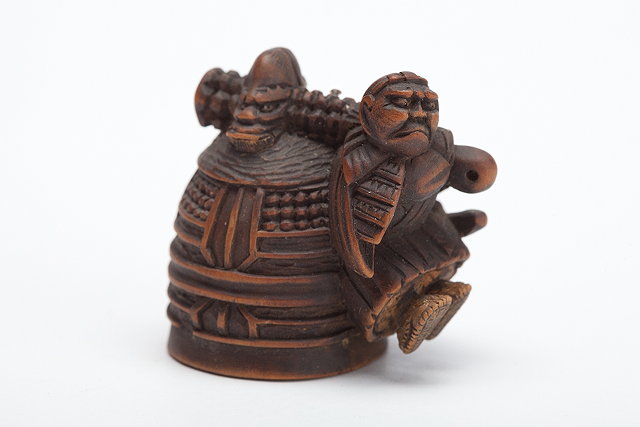 Appraisal: A JAPANESE WOOD NETSUKE of Benkei carrying the huge Meidera