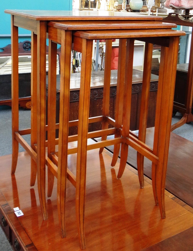 Appraisal: A nest of three tulipwood banded satinwood occasional tables on