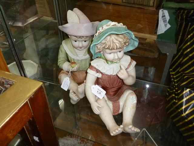 Appraisal: A PAIR OF PORCELAIN FIGURES of a boy and a