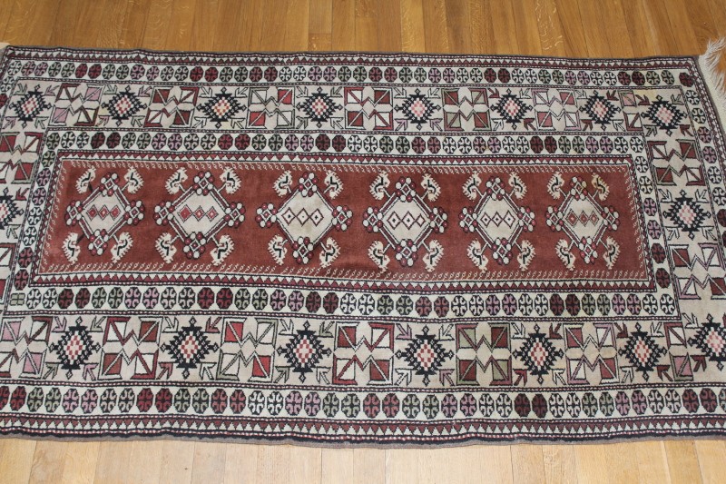 Appraisal: An Eastern bordered rug on a brown and magenta ground