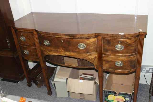 Appraisal: A TH CENTURY MAHOGANY SIDEBOARD with bow front and fluted