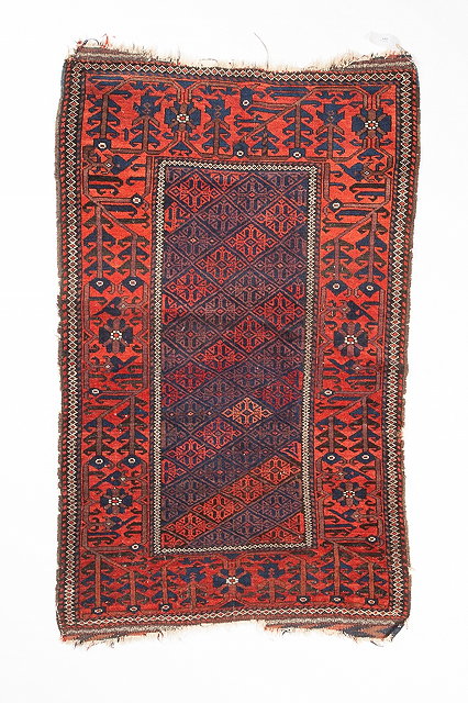 Appraisal: AN OLD BELOUCH WINE GROUND RUG with central geometric panel