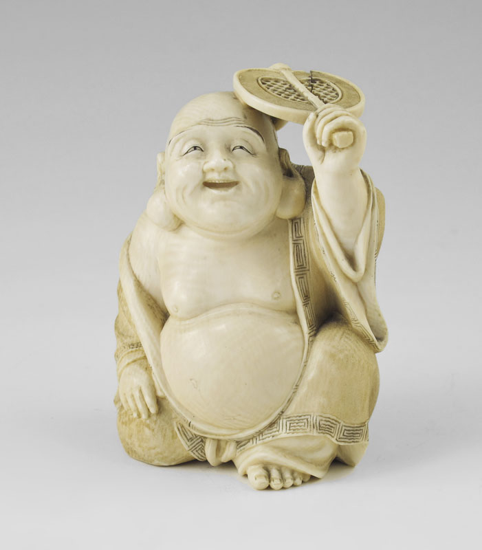 Appraisal: CARVED IVORY BUDDHA HOLDING FAN Figure of squatting Buddha holding