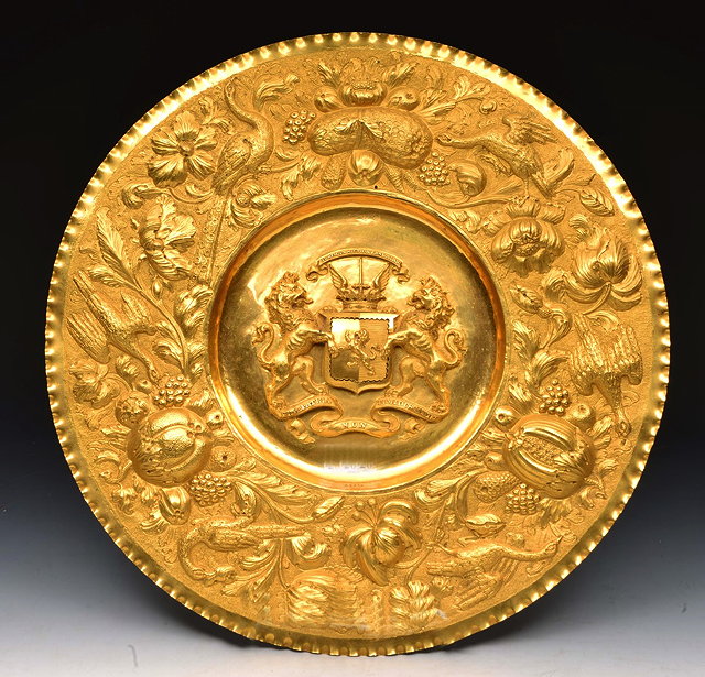 Appraisal: A GILDED BRASS ALMS DISH the central coat of arms