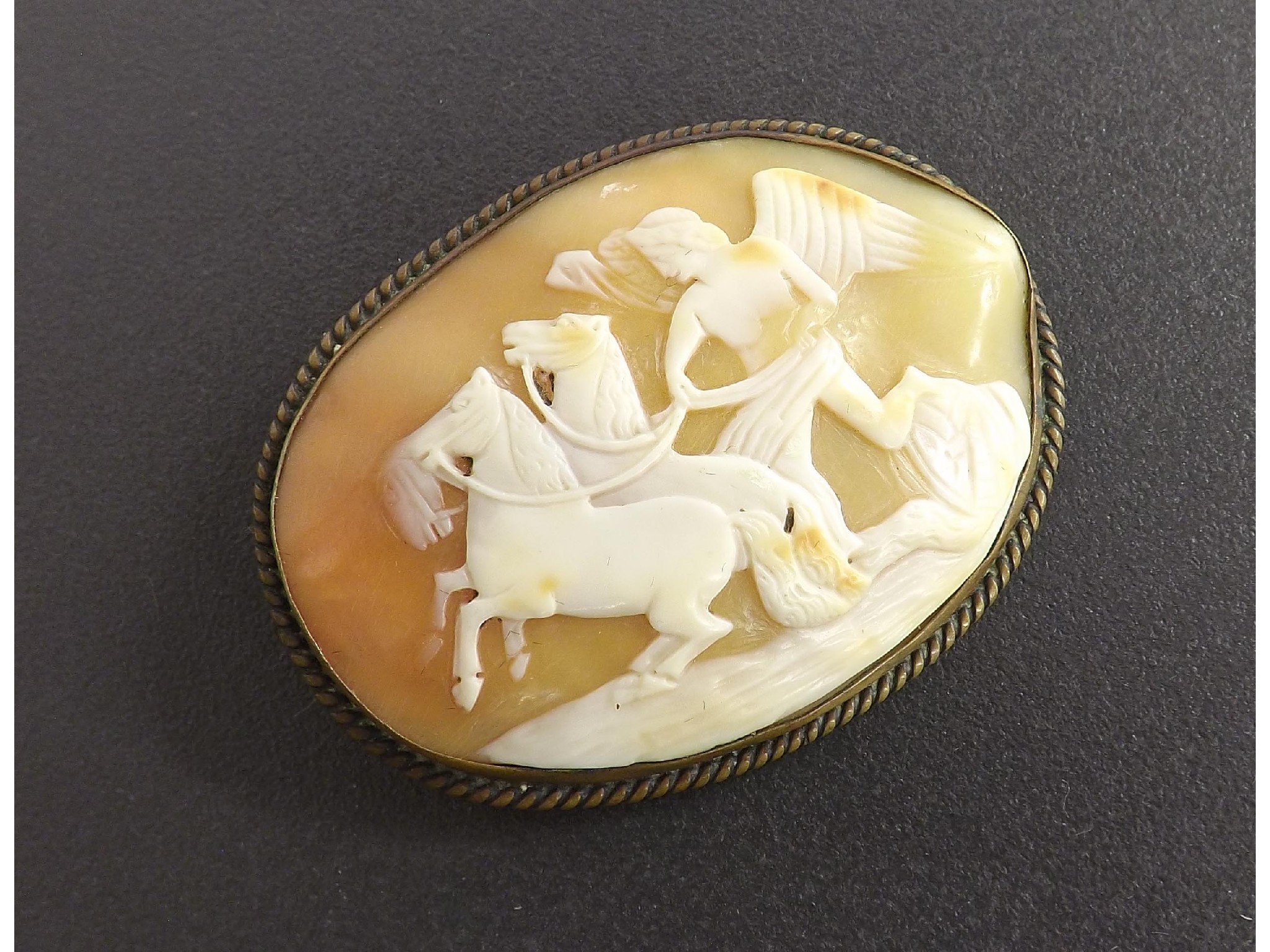 Appraisal: Carved shell cameo brooch depicting a winged chariot rider with