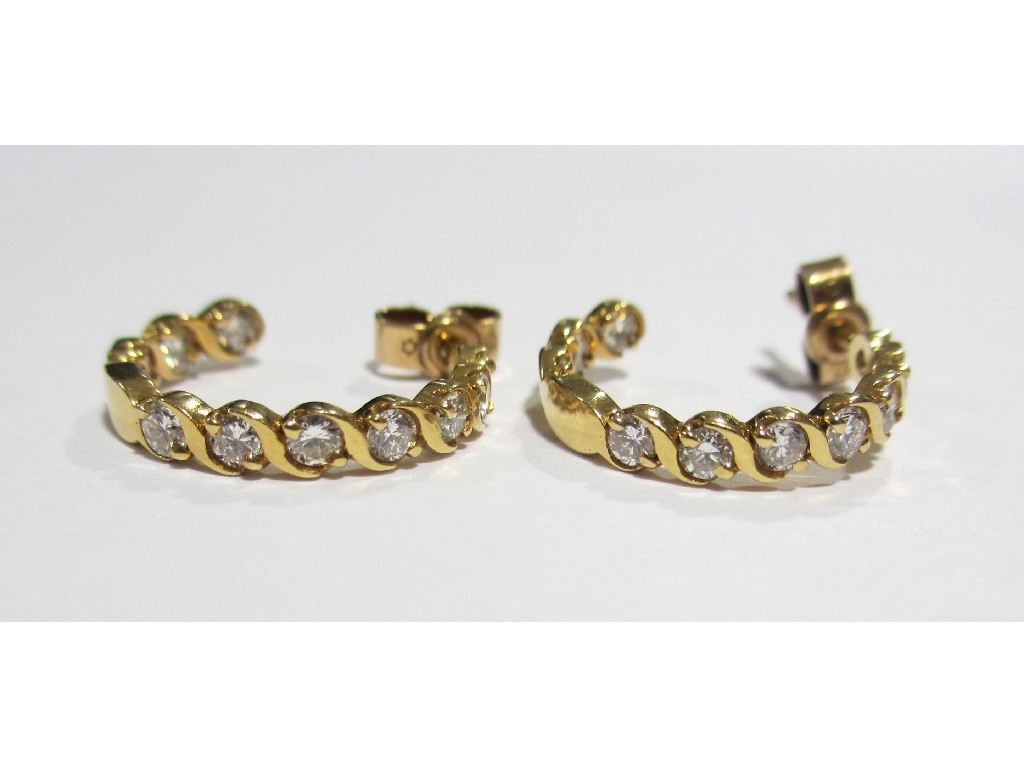 Appraisal: A pair of diamond hoop earrings each set with seven