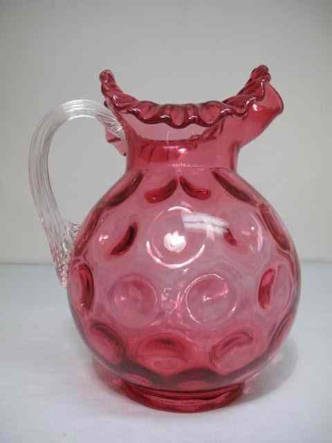 Appraisal: Cranberry ''Thumbprint'' glass pitcher Cranberry body with clear glass handle