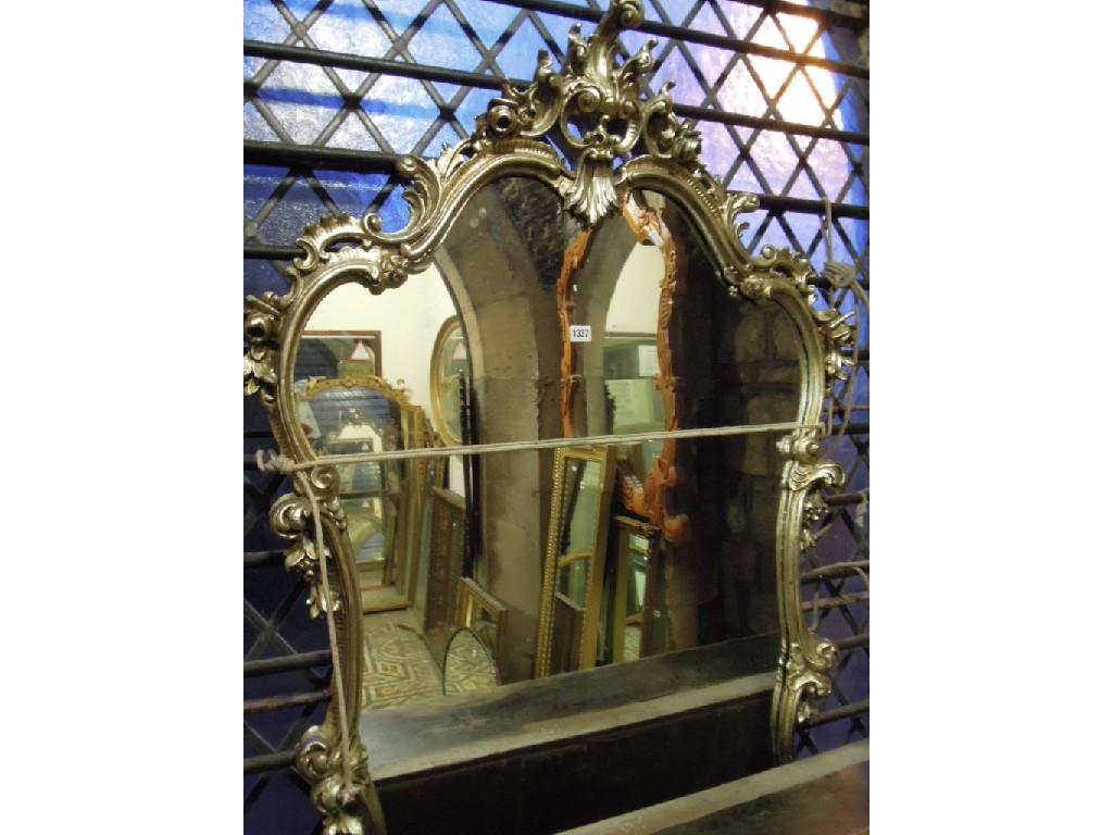 Appraisal: A reproduction over mantle mirror with silver coloured shaped and