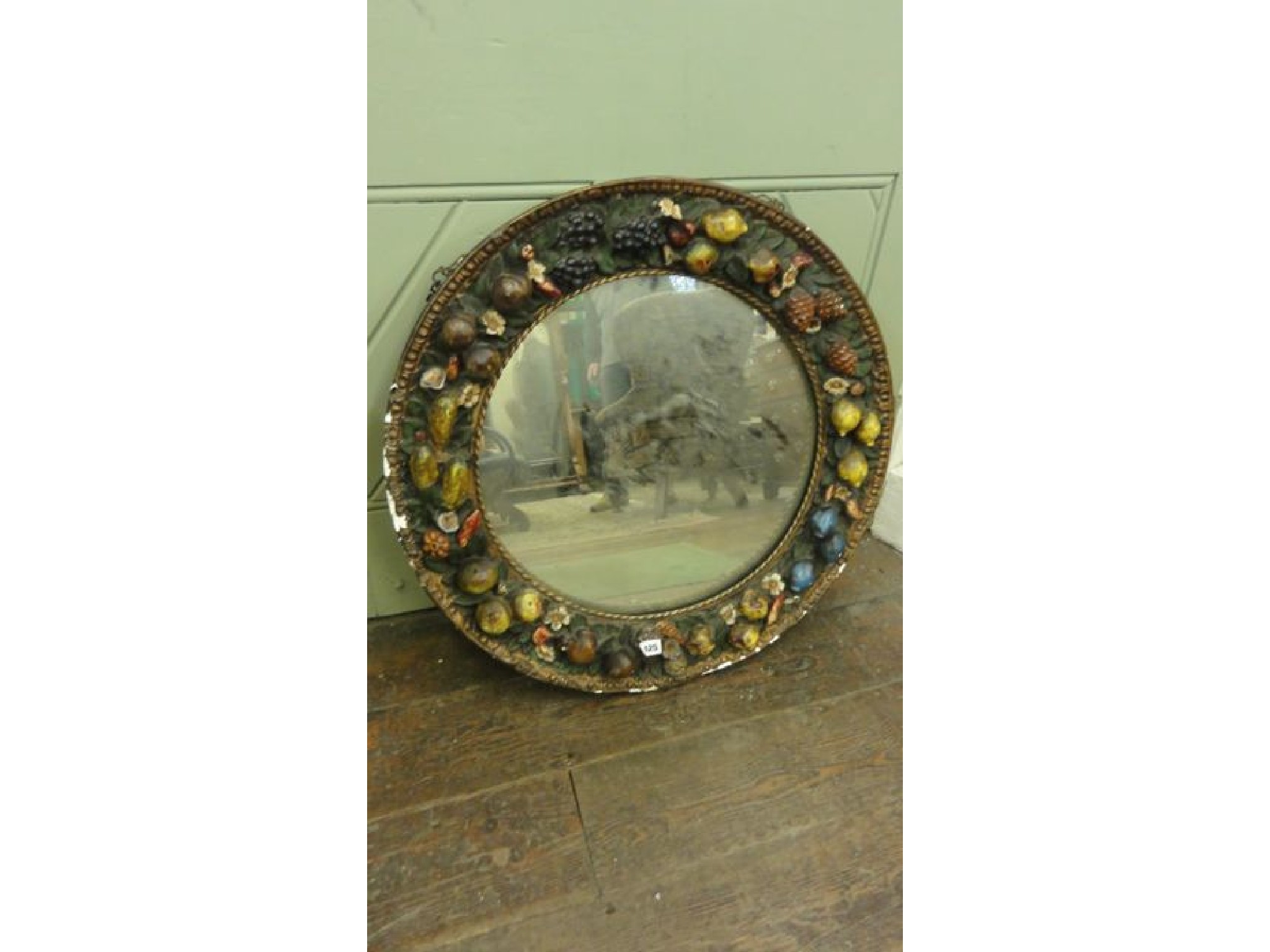 Appraisal: A circular mirror set in a deep relief plaster frame