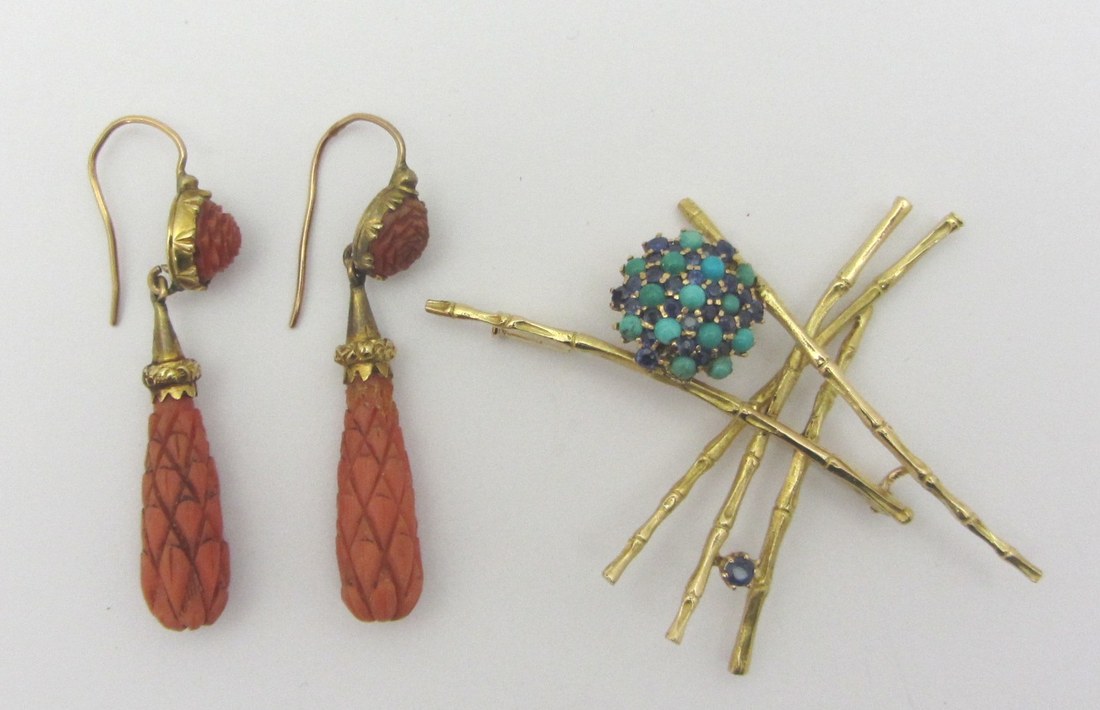 Appraisal: A pair of carved coral pendant earrings the tops with