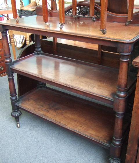 Appraisal: A Victorian mahogany three tier buffet the shaped surmount with