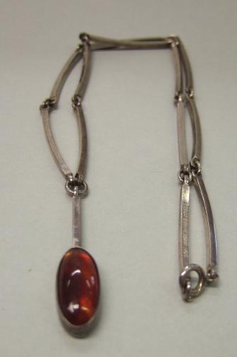 Appraisal: A Sterling and amber pendant necklace in a curved baton