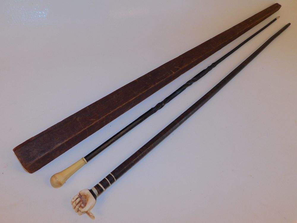 Appraisal: PLANTATION CANES antique plantation canes flexible leather-wrapped shaft with carved