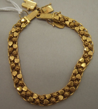 Appraisal: A gold bracelet in an interwoven link design with filigree