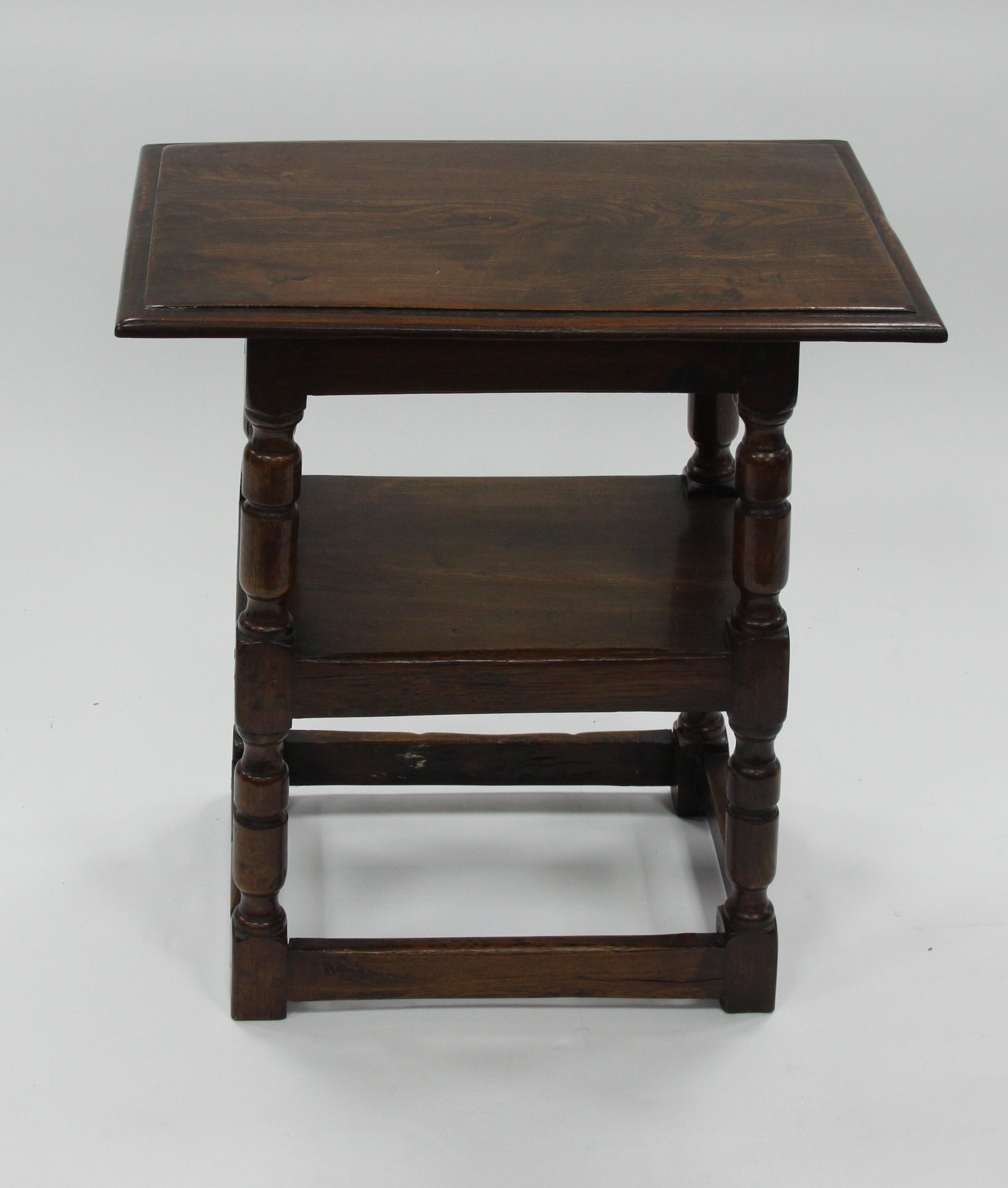 Appraisal: An oak two-tier table on baluster supports and square stretchers