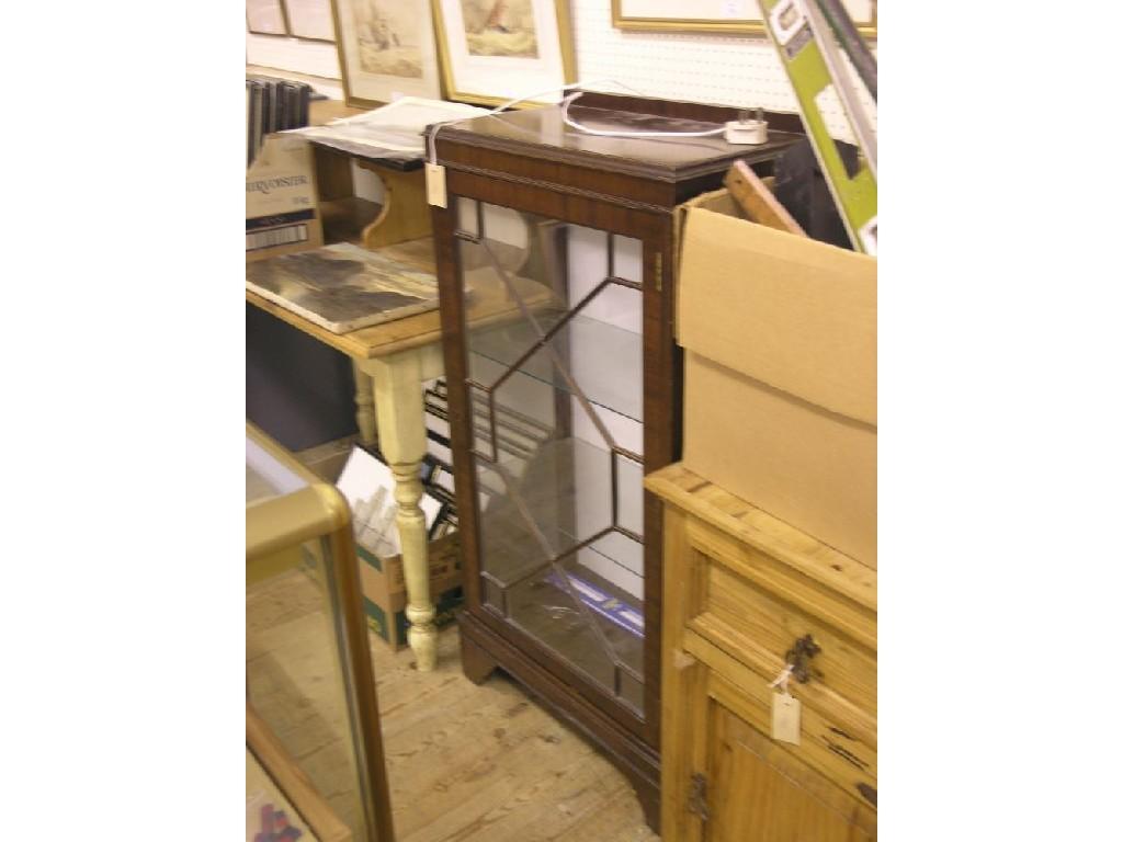 Appraisal: A reproduction mahogany display cabinet enclosed by single astragal-glazed door