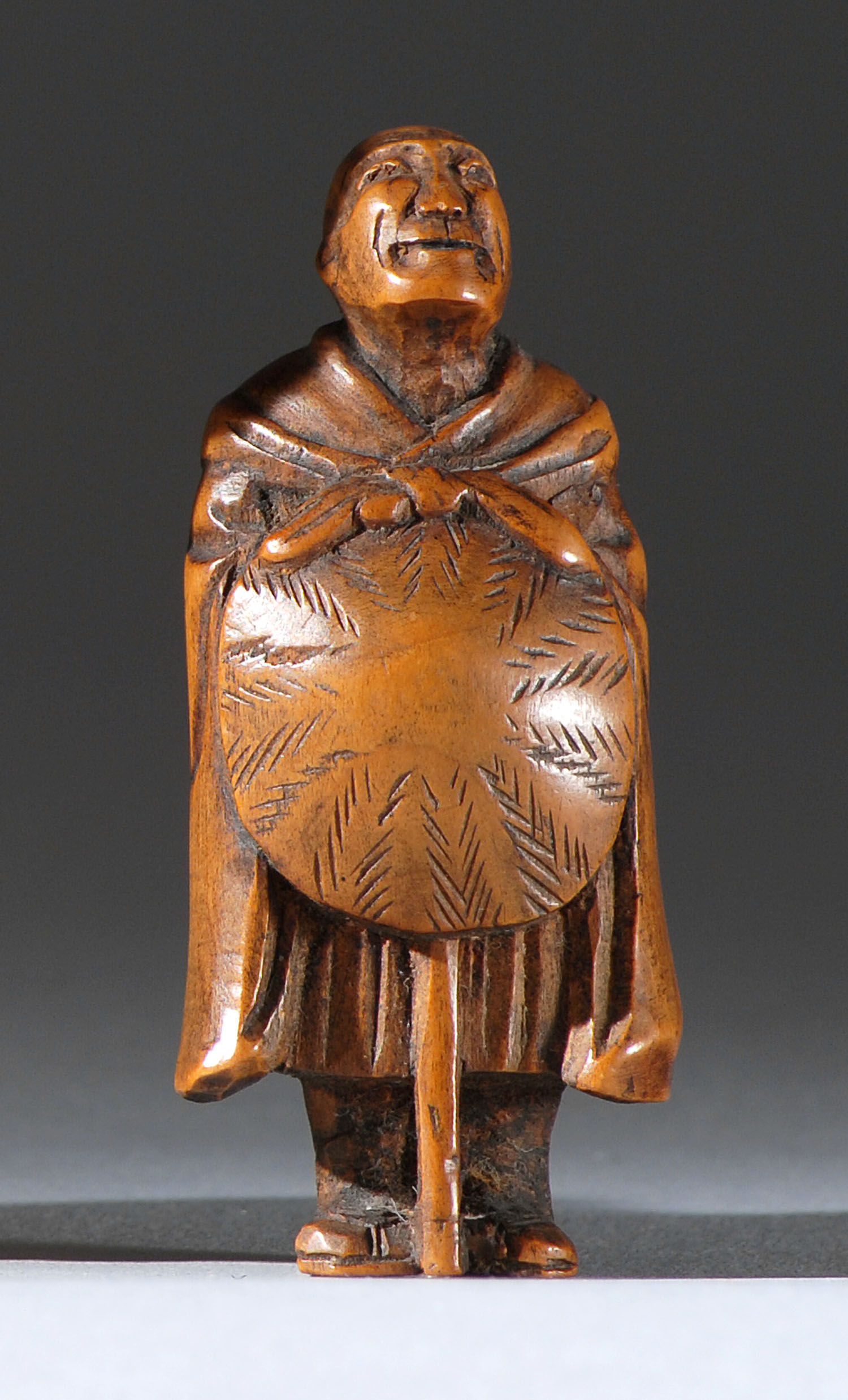 Appraisal: WOOD NETSUKE th CenturyIn the form of a mendicant holding