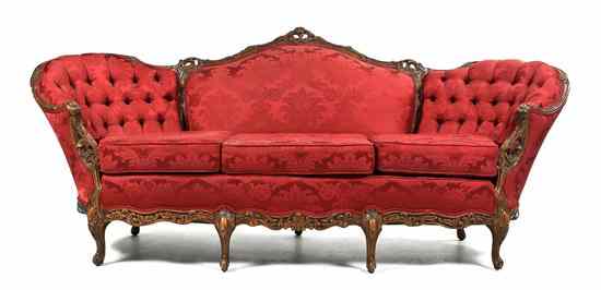 Appraisal: A Victorian Style Camelback Carved Sofa having a pierce carved