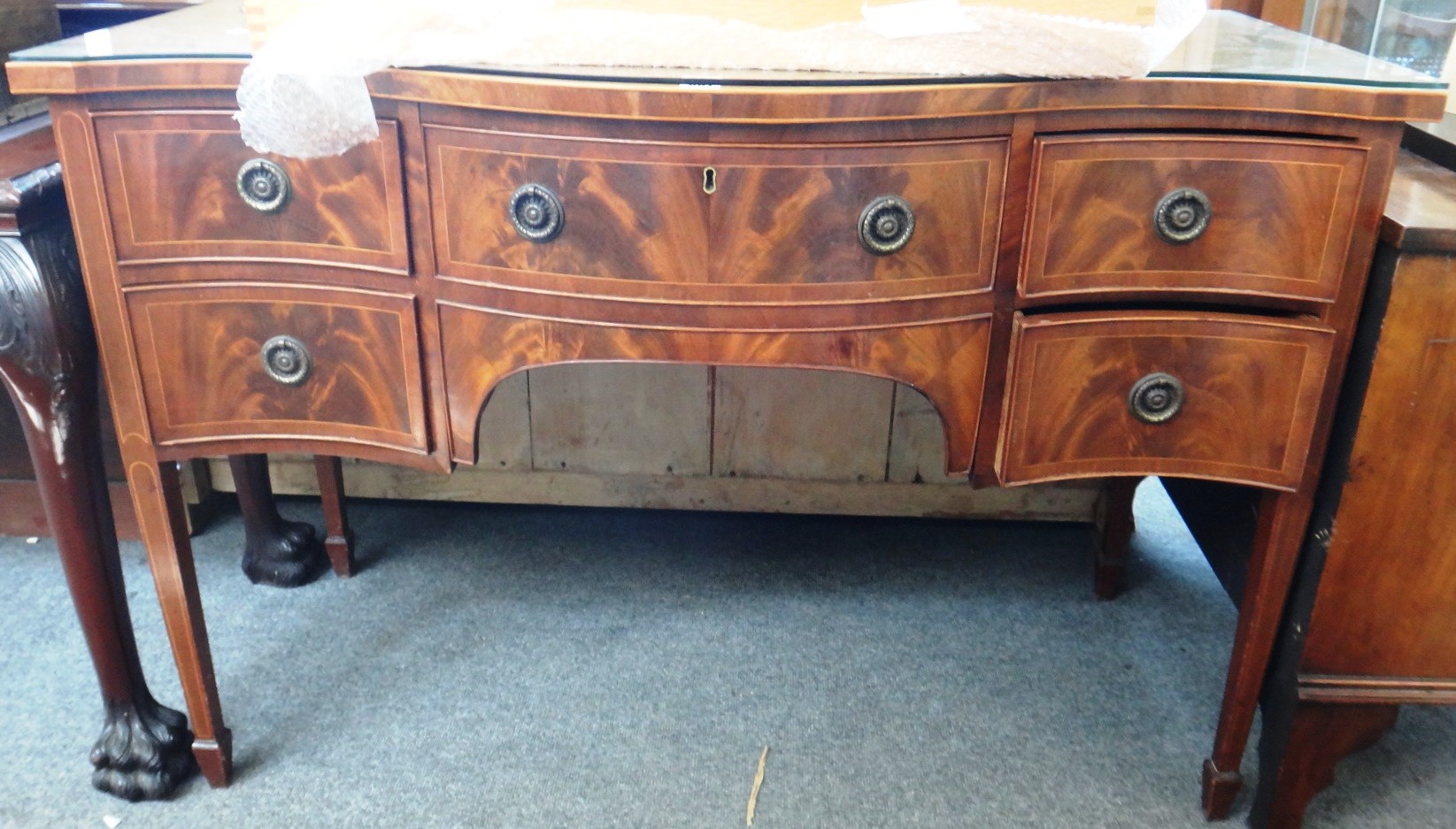 Appraisal: A th century inlaid mahogany serpentine sideboard with five frieze