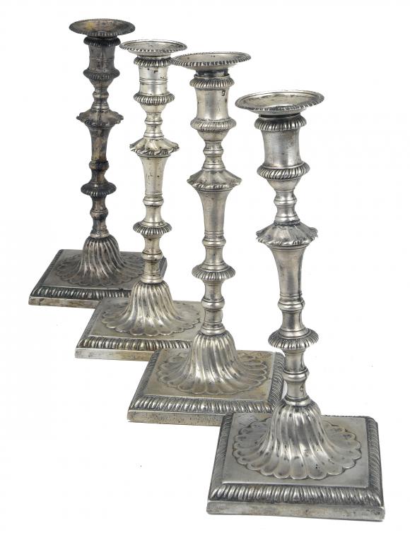 Appraisal: FOUR GEORGE III CANDLESTICKS the gadrooned nozzle in waisted sconce