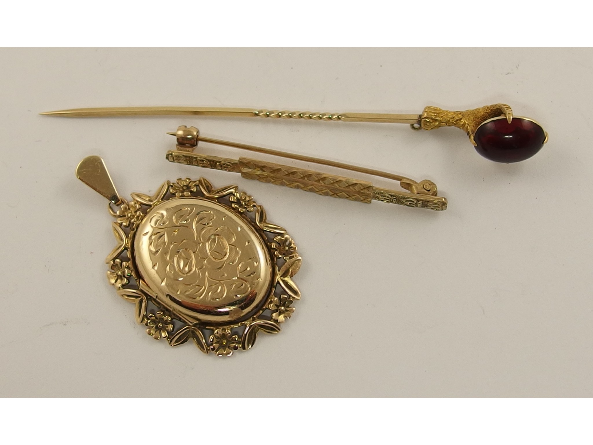 Appraisal: A yellow metal eagles claw garnet topped stick pin a