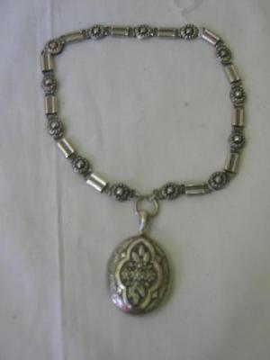 Appraisal: A VICTORIAN SILVER LOCKET of oval form moulded with flowers