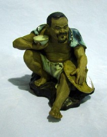 Appraisal: A Japanese figure of a seated fisherman in glazed stoneware